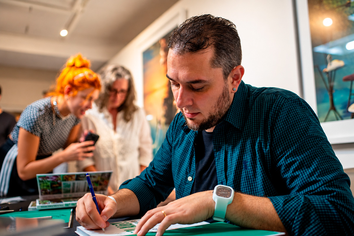 Autor autografando um livro durante lançamento