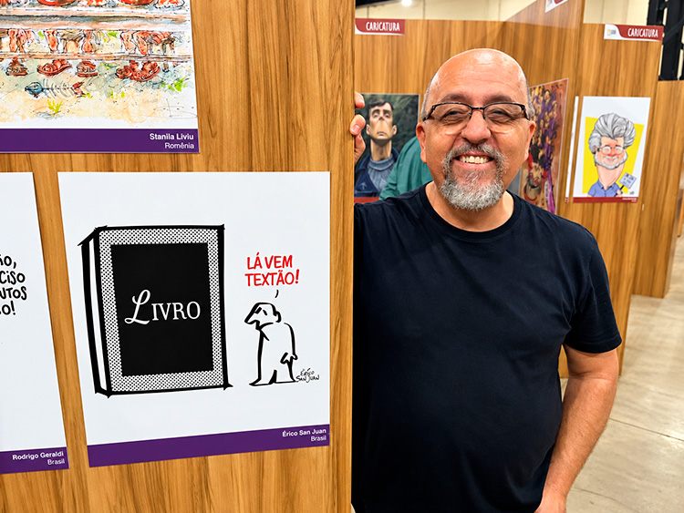 Érico San Juan ao lado de caricatura exposta em mostra